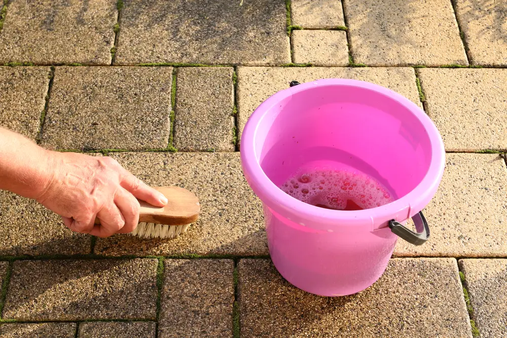 Cleaning patio with brush